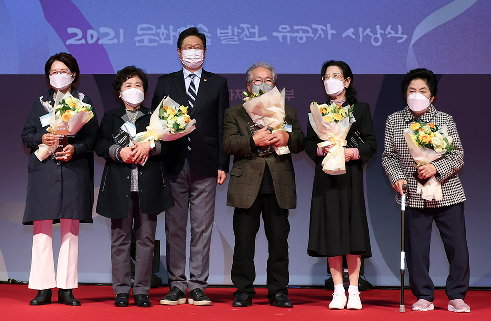 황희 문화체육관광부 장관이 22일 서울 중구 국립극장 달오름극장에서 열린 문화예술발전 유공자 시상식에서 예술가의 장한 어버이상을 시상하고 수상자와 기념촬영을 하고 있다. 왼쪽부터 공연연출가 남인우 씨의 어머니 공연식 여사, 판화가 이윤엽 씨의 어머니 김학년 여사, 황 장관, 시인 박준 씨의 아버지 박상수 선생, 뮤지컬 제작자 조윤진 씨의 어머니 서복경 여사, 국악인 윤진철 씨의 어머니 전정자 여사.