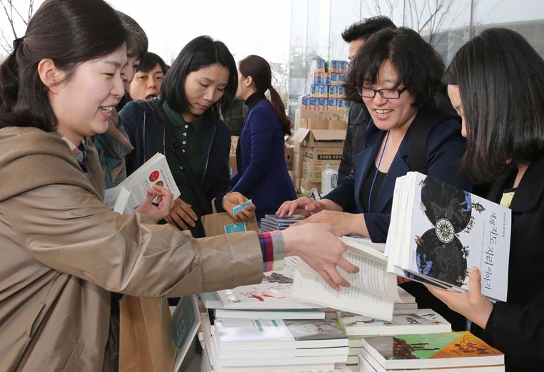 행사장을 방문한 시민들이 책을 교환하고 있습니다.