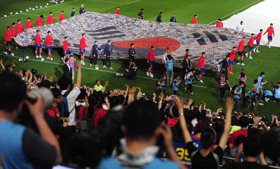 대형태극기를 들고 그라운드를 돌고 있는 축구대표팀과 홍명보 감독