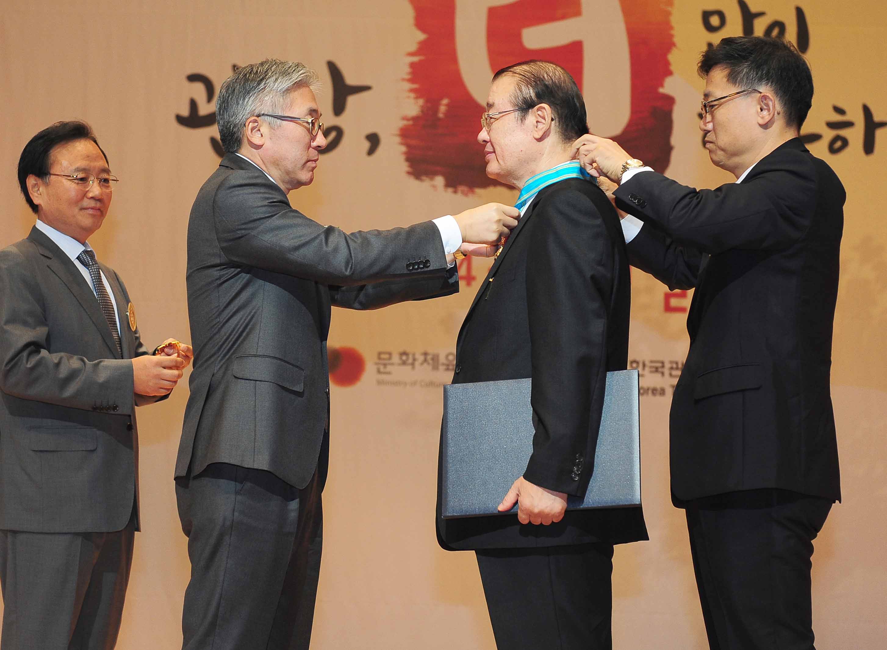 김종덕 문화체육관광부 장관이 한국 마이스(MICE)산업의 발전을 견인해온 정현모 ㈜코리아컨벤션서비스 대표이사에게 은탑산업훈장을 수여하고 있다.
