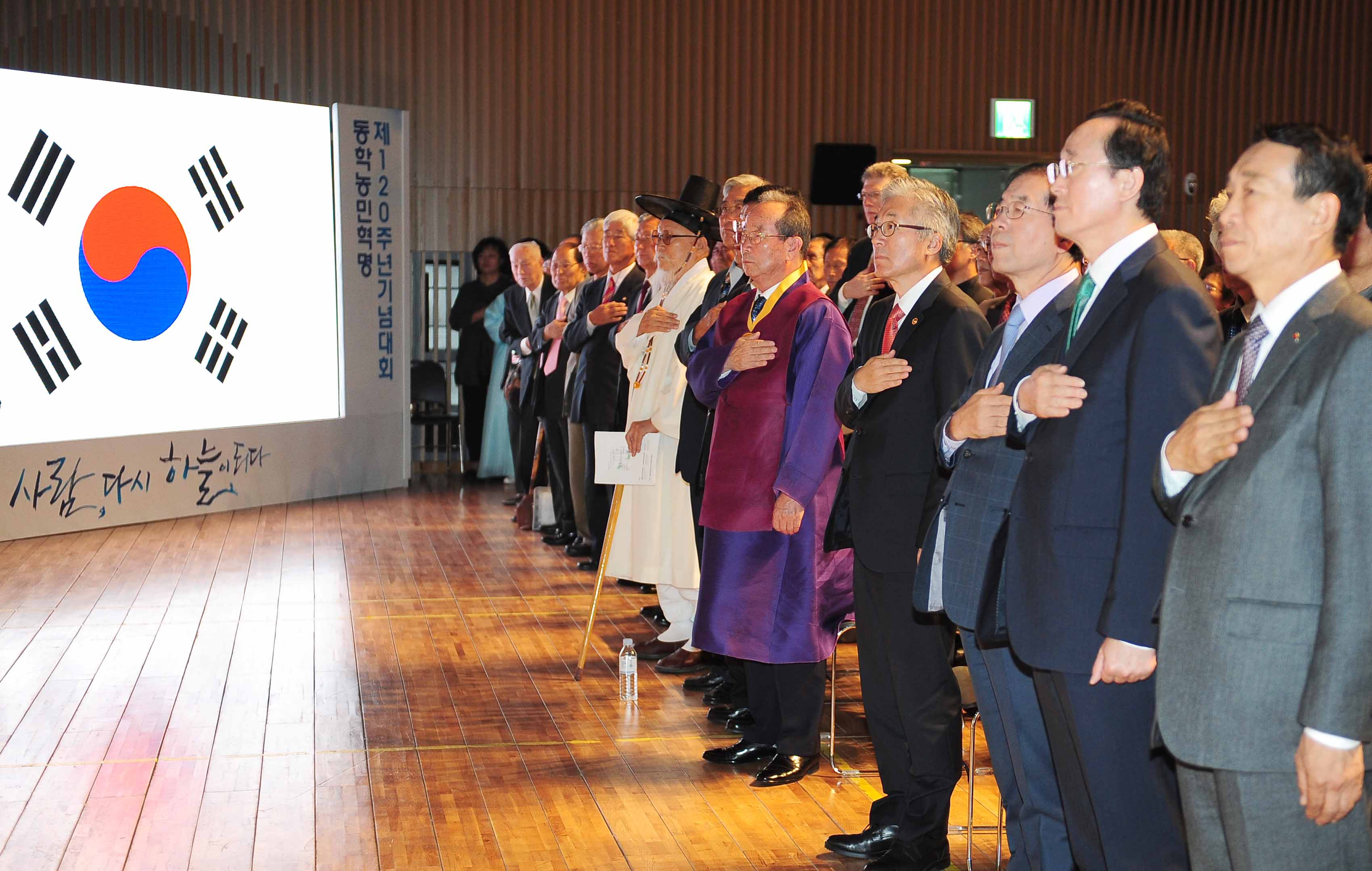 김종덕 문화체육관광부 장관이 김대곤 동학농민혁명기념재단 이사장, 김석태 전국동학농민혁명유족회 회장, 박남수 천도교 중앙총부 교령 등 주요 내빈들과 국민의례를 하고 있다.