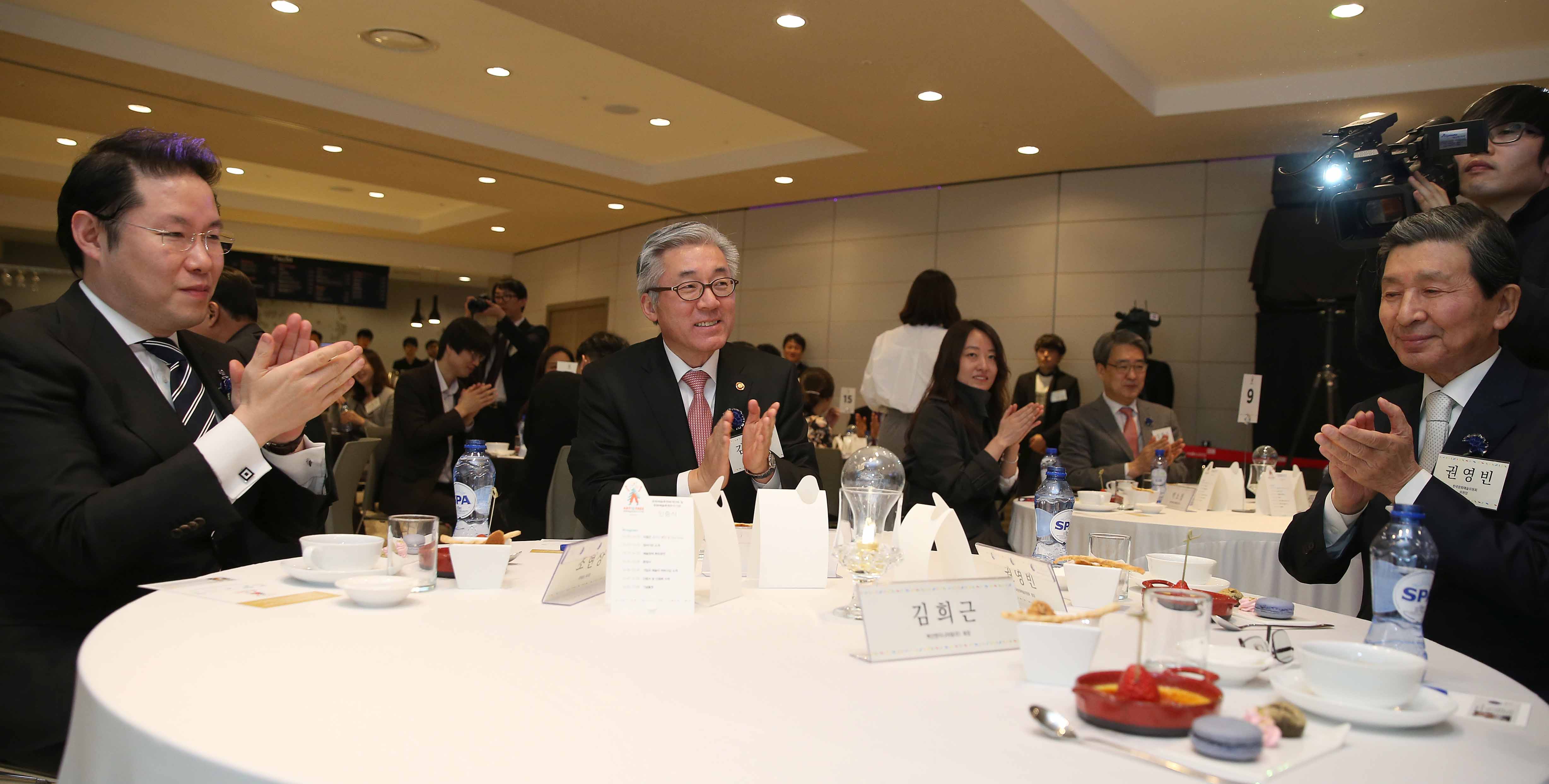김종덕 문화체육관광부 장관이 오프닝 행사로 컵에 물을 붓고 전구를 넣어서 전구에 불이 켜지게 하는 퍼포먼스를 마친 뒤에 권영빈 한국문화예술위원회 위원장 등 내빈들과 박수를 치고 있다