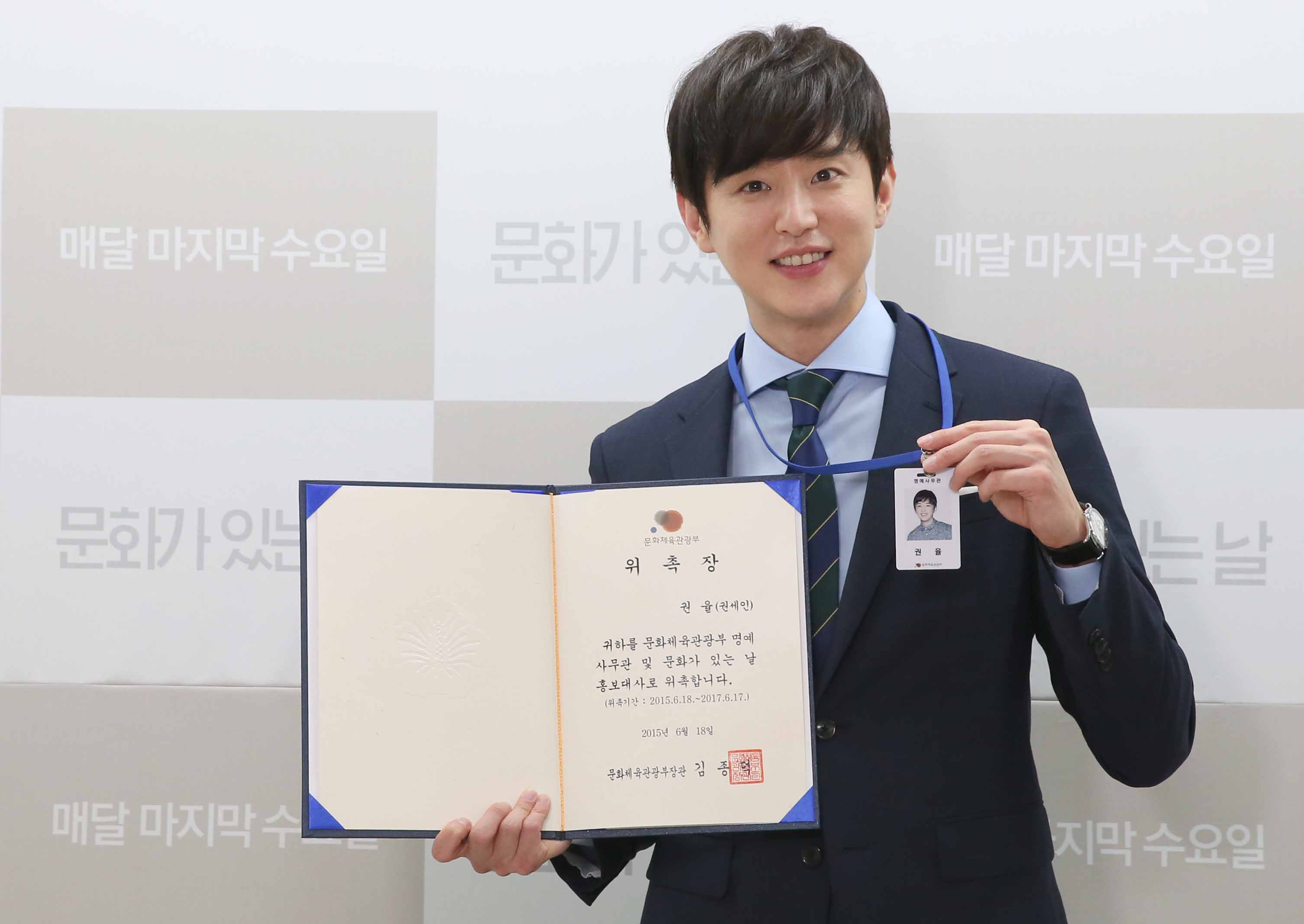 명예사무관증을 들고 사진을 찍는 권율