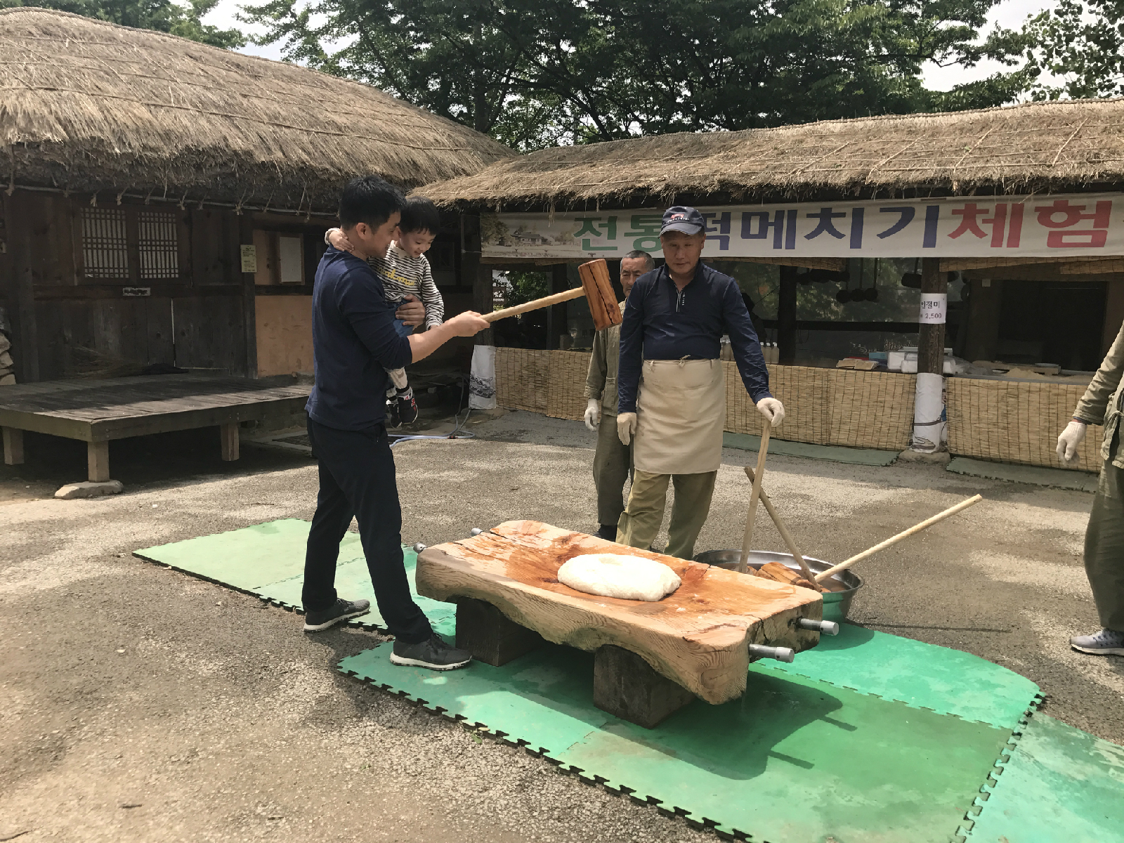 아이와 함께 떡메치기 체험을 하고 있는 모습