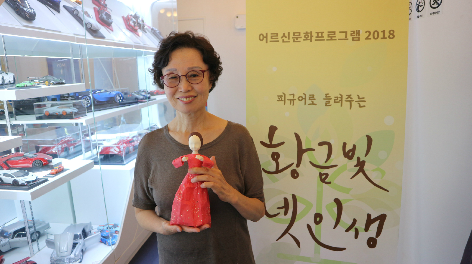 수강생인  본인이 만든 닥종이 인형을 들고 있는 김매자 어르신 