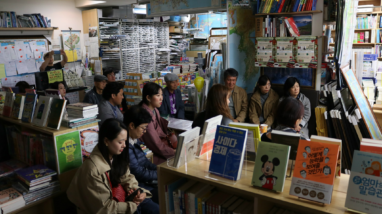 사람들이 서점에 앉아 낭독극에 집중해서 듣고 있다