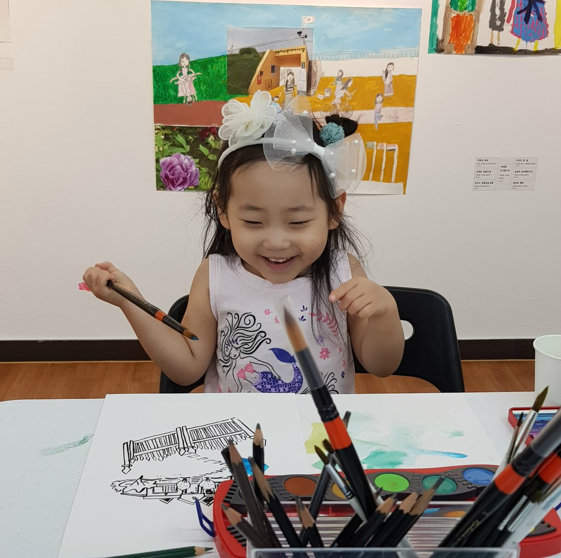 그림을 그리며 행복해 하는 어린이