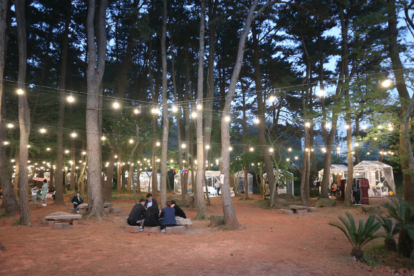 돌로 만든 탁자에서 식사하는 방문객들