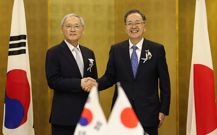 문체부 유인촌 장관과 일본 국토교통성 사이토 테츠오 대신이 양국기를 배경으로 악수하는 모습